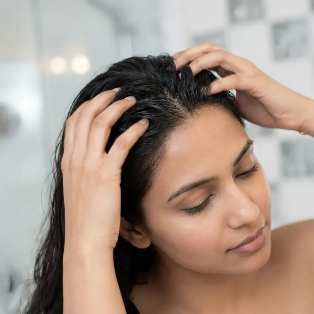 a women massaging ayurvedic hair oil
